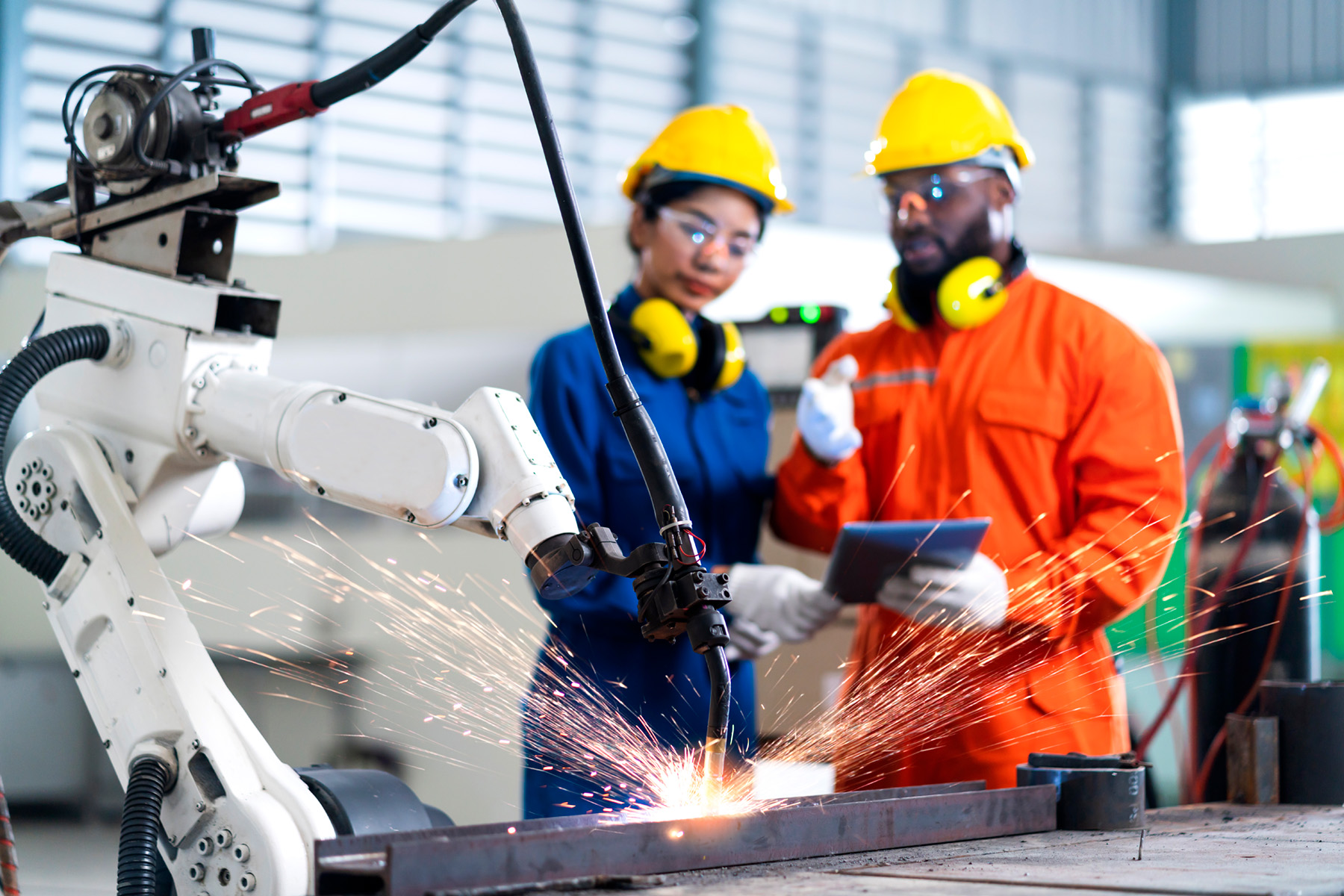 Robotic welder in action with workers observing